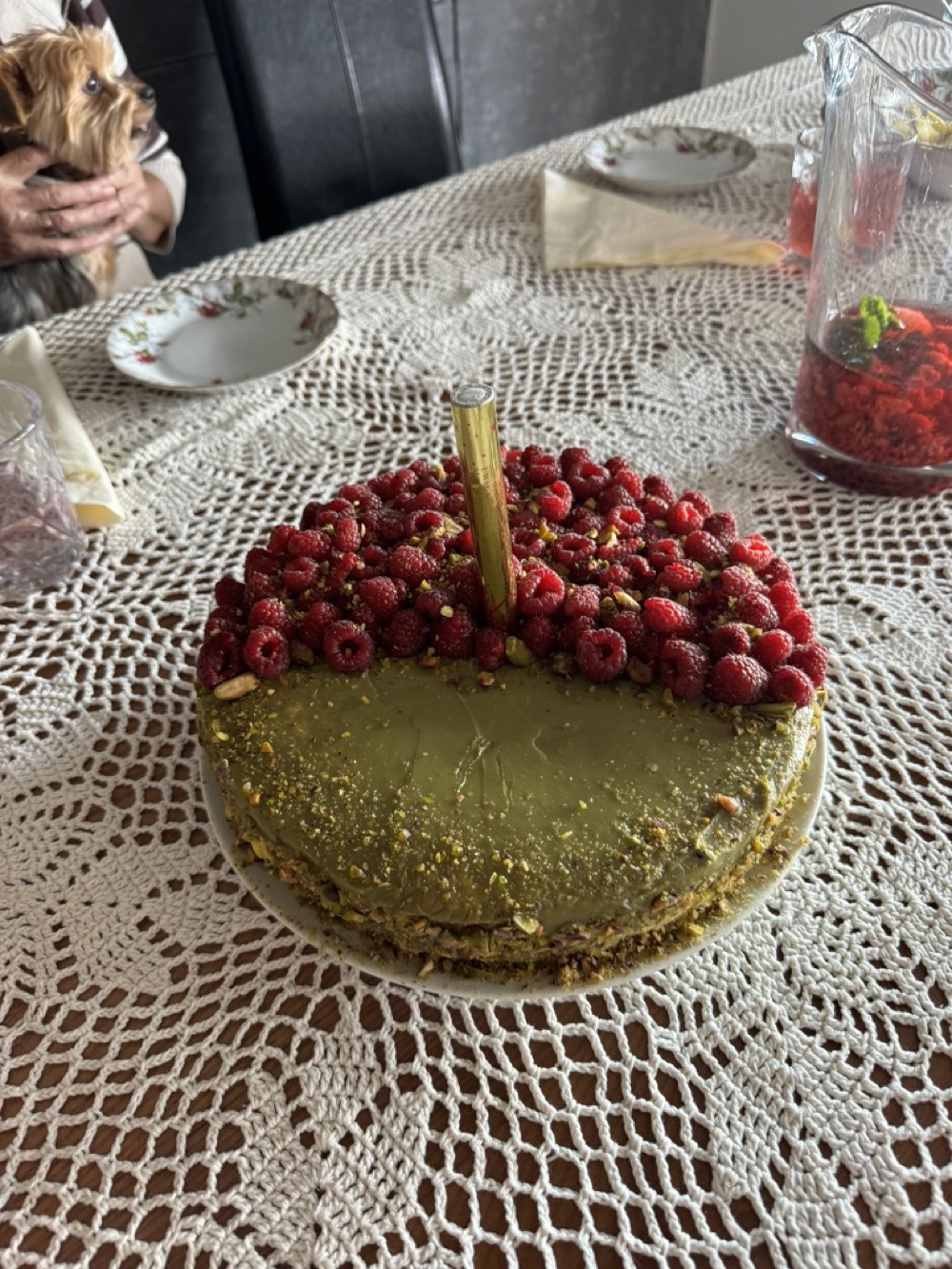Tort w pistacjowej otulinie z posypką pistacjową i świeżymi malinami